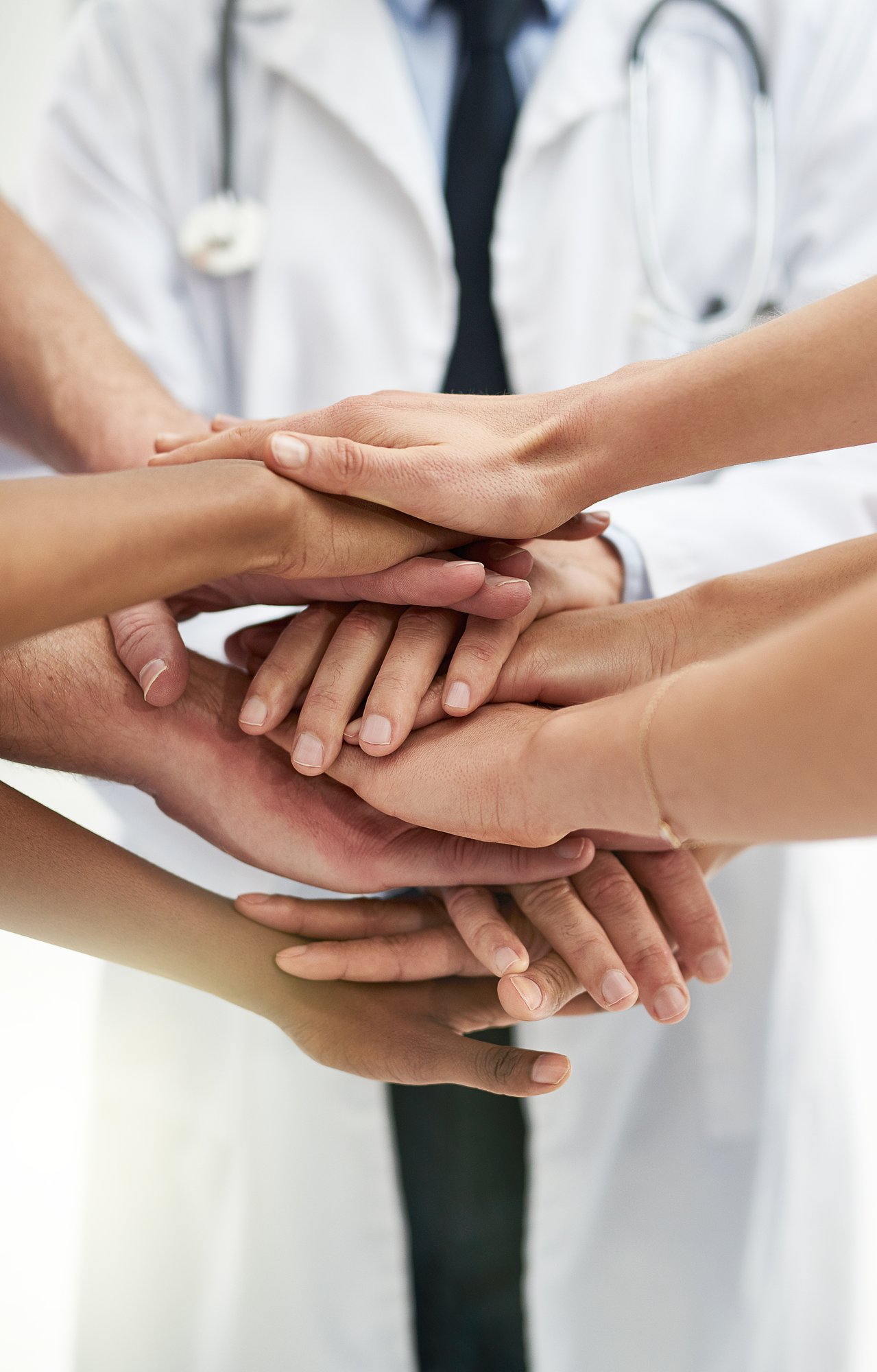 Doctors and nurses with their hands stacked