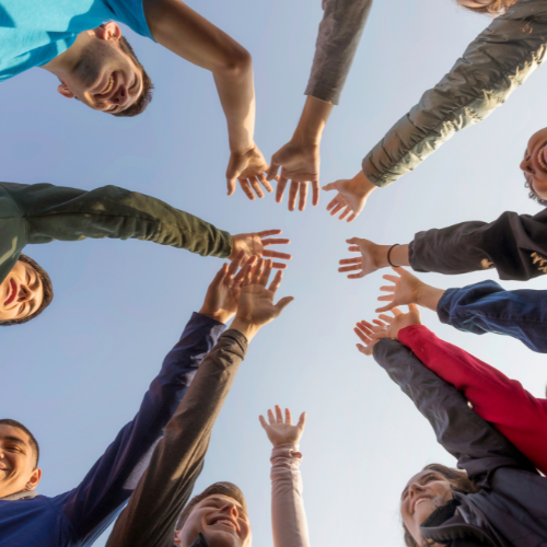 People in a group with their hands together in the middle