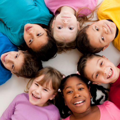 children laying in a circle with their heads teaching