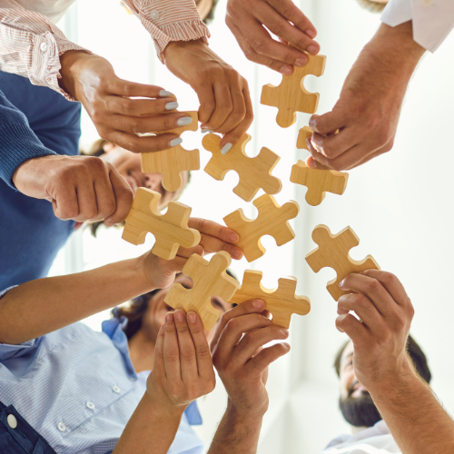 group of people holding puzzle pieces