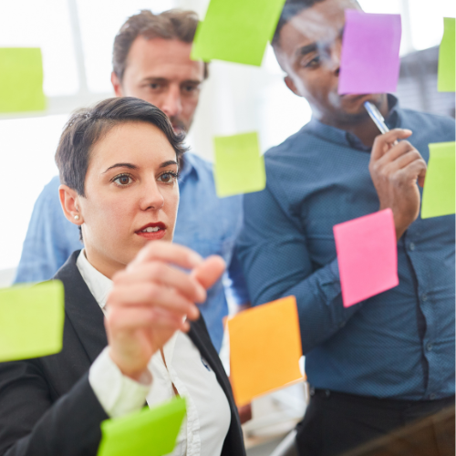 people looking at a wall of sticky notes