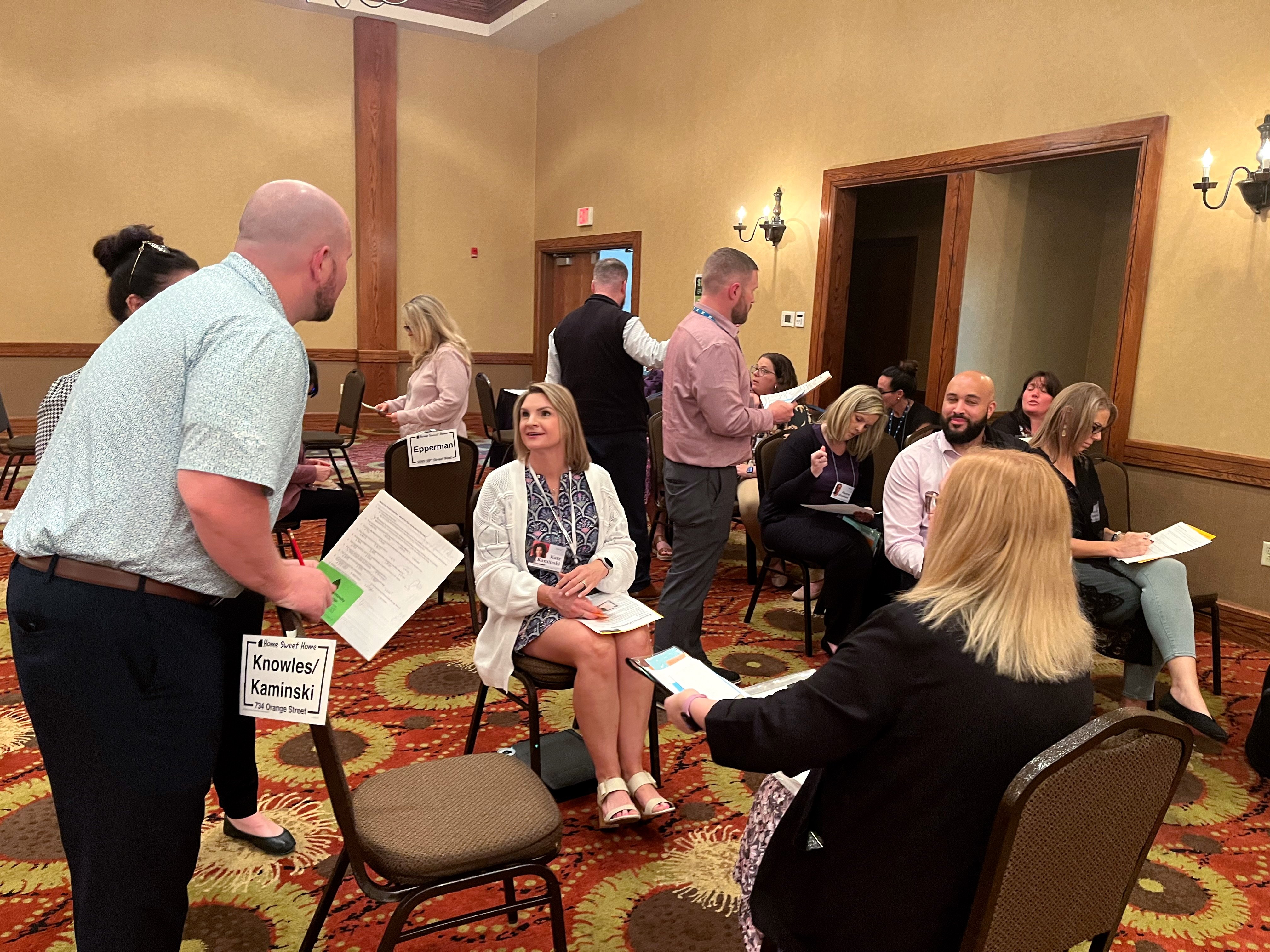 Groups of families at their homes at the Quality Insights Community Action Poverty Simulator
