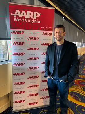 Quality Insights Chief Information and Security Officer Nathan Gibson in front of an AARP West Virginia banner