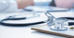 clipboard with a stethoscope draped over it