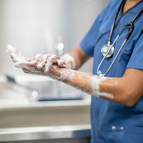 medical professional washing hands with soap and water
