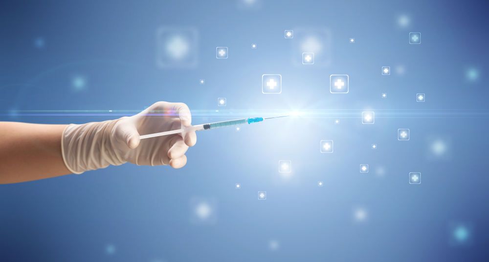 Female doctor hand holding syringe with shiny crosses in the background