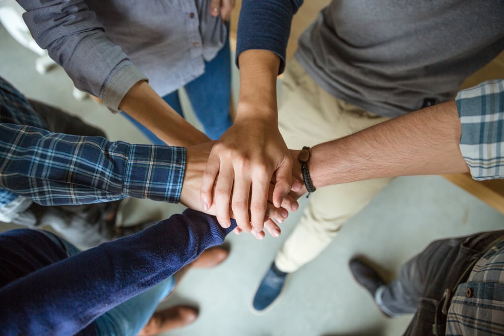 Top view of people joining hands together as a symbol of partnership-1