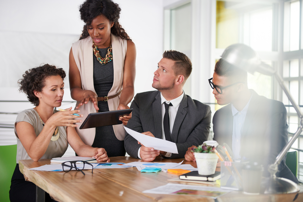 team of successful business people having a meeting in executive sunlit office