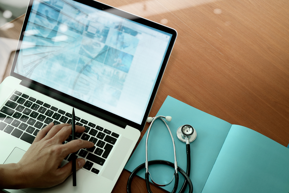 top view of Medicine doctor hand working with modern computer and smart phone on wooden desk as medical concept-Jan-30-2023-02-18-41-5572-PM